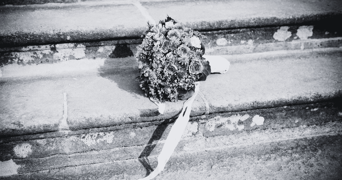 石の階段の上に置かれたブーケ。モノクロの写真。
