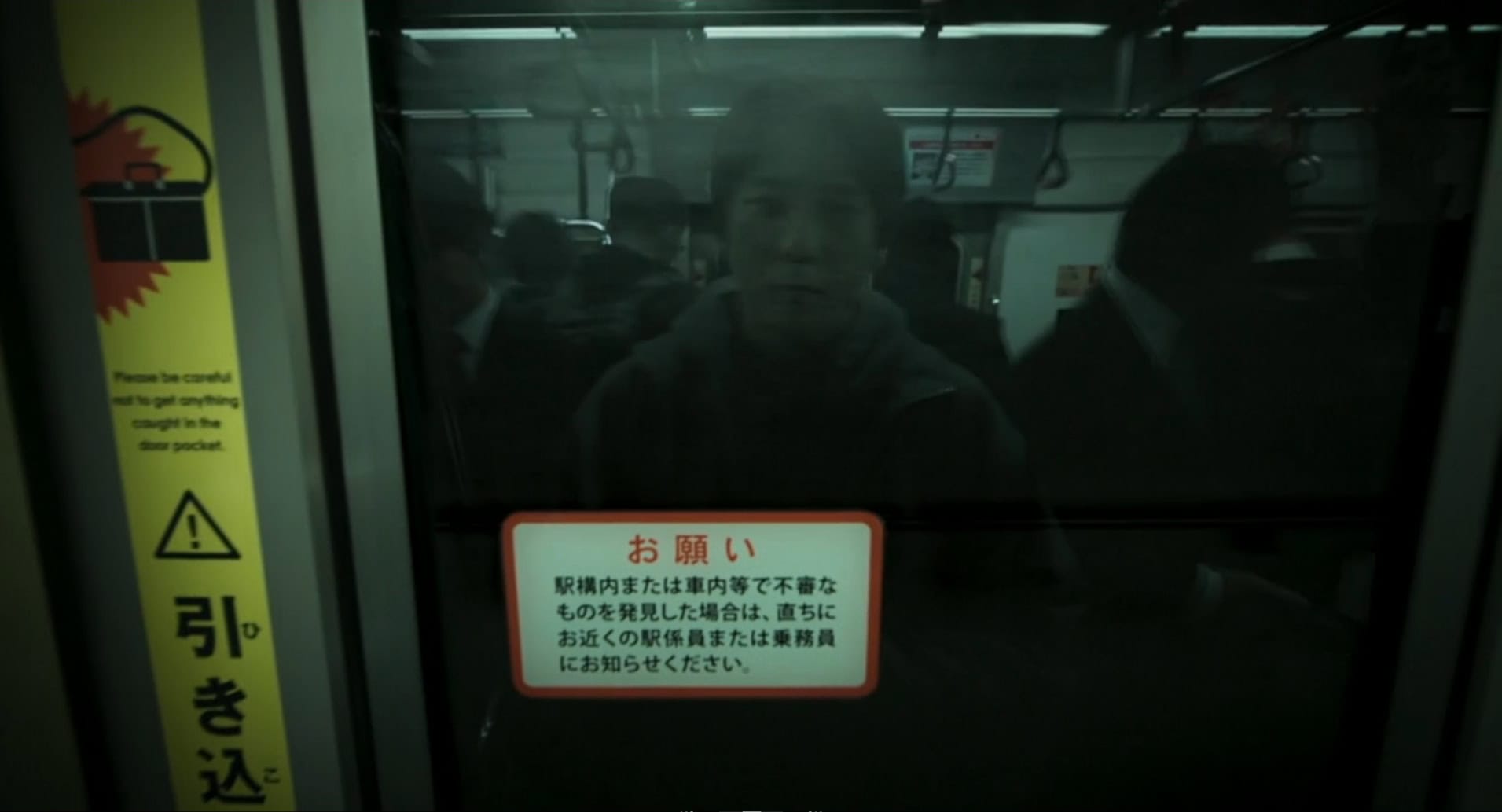 The protagonist's face reflected in a subway train window.