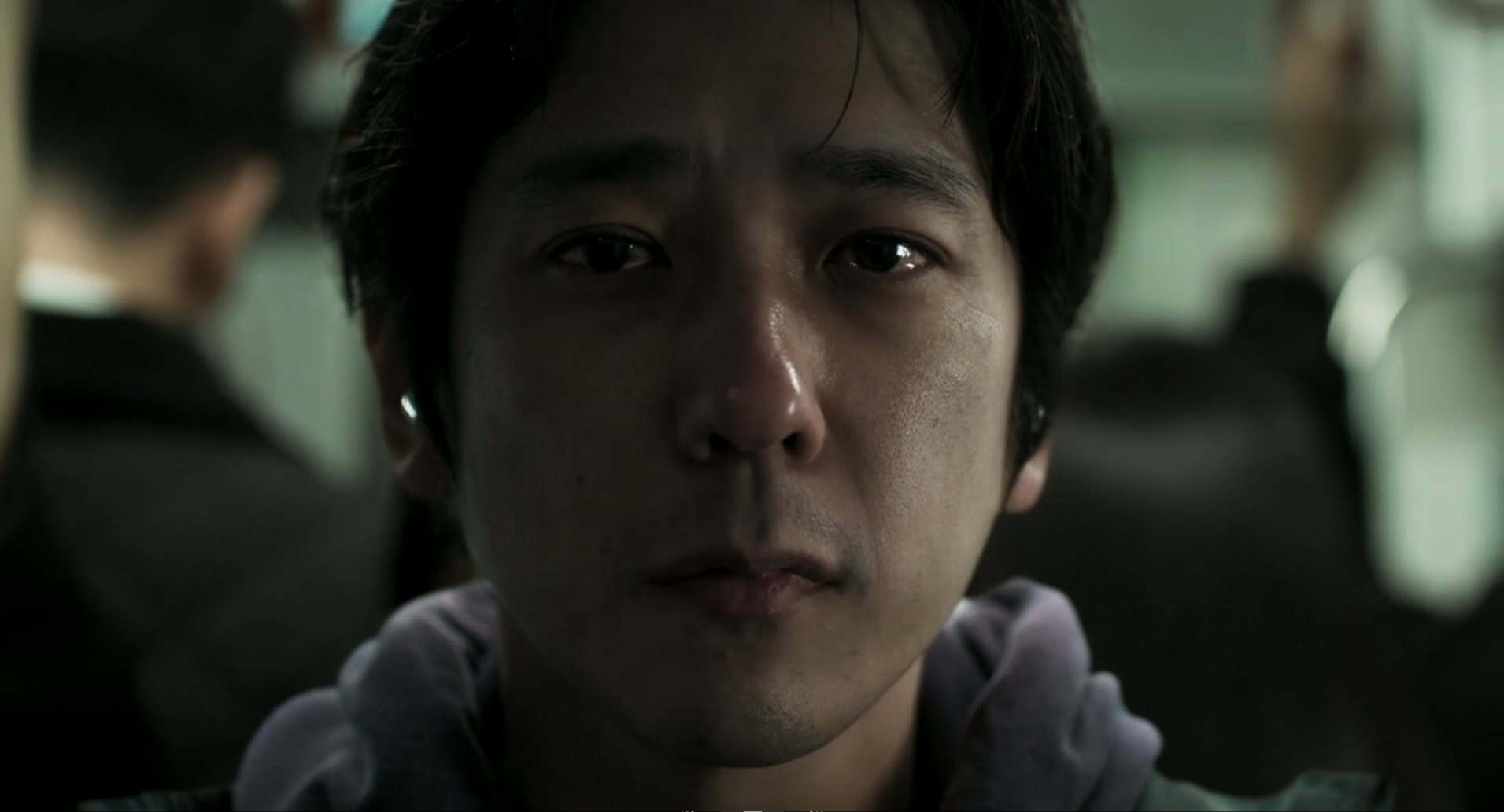 A frontal close-up of the protagonist inside the subway train.